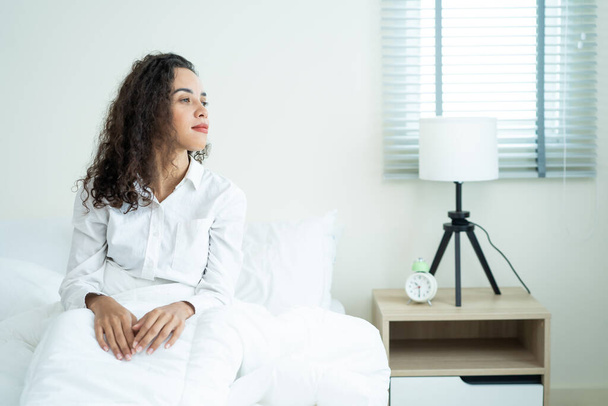 Portrait of Beautiful Latino girl in pajamas getting up with happiness. Attractive young woman feel fresh and happy to wake up early from bed in bedroom in morning at home. healthy lifestyle concept. - Foto, Imagen