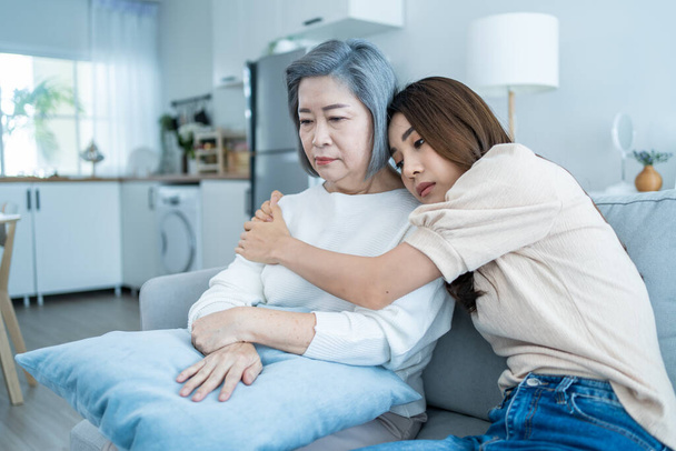 Asian loving daughter comforts upset elderly mother crying for problem. Young caring woman support, consoling and understand empathy to stressed senior older mom in tears at home. Family relationship. - Foto, Imagem