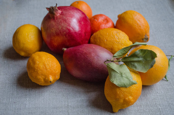 Fruits bergamot, pomegranate, lemon, pamelo, pear, tangerine, mango on a wooden background. Vitamin still life. - Fotografie, Obrázek