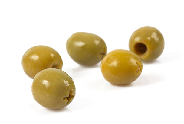 Green olives on a white background. Olives on a white background. Top view. Pitted green olives on white background. Close up. - Фото, изображение
