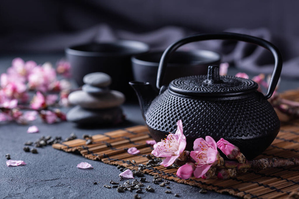 Teekanne und Teetassen mit blühenden Mandelzweigen - Foto, Bild