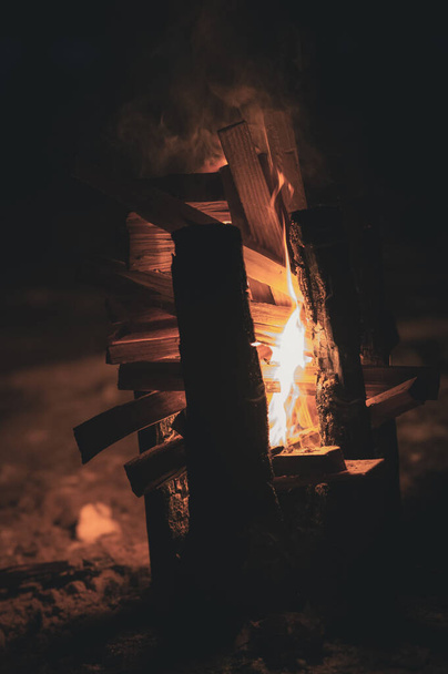 kouř z plamenů ohně a dřevěná tyč hořící svisle z drážek nahoře, takže oheň lépe spaluje dřevo zevnitř jako pochodeň - Fotografie, Obrázek