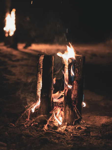 smoke from the flames of the fire and a wooden pole burning vertically from the grooves notched at the top, so that the fire better burns the wood from the inside like a torch - Photo, Image