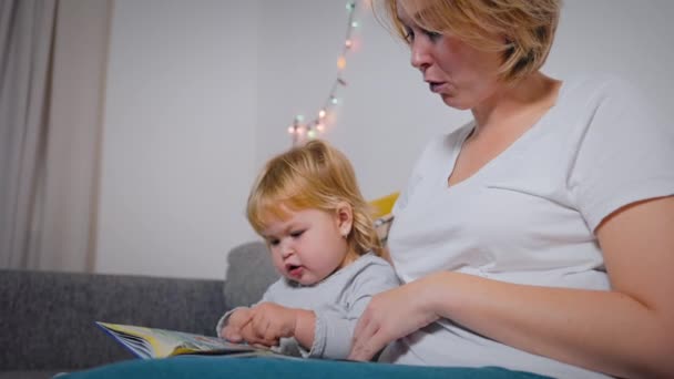 Young mother is engaged in reading with her a little autistic child. Pronunciation and speech therapy. Slow motion - Filmagem, Vídeo
