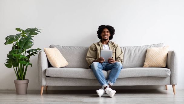 Millennial African American Guy Resting With Digital Tablet On Couch - Zdjęcie, obraz