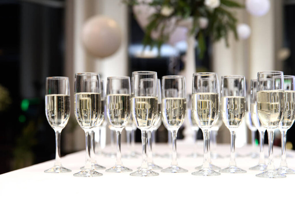 Muchas copas de vino con champán o vino blanco. .. muchas copas con champán durante la mesa de fiesta. enfoque selectivo - Foto, imagen