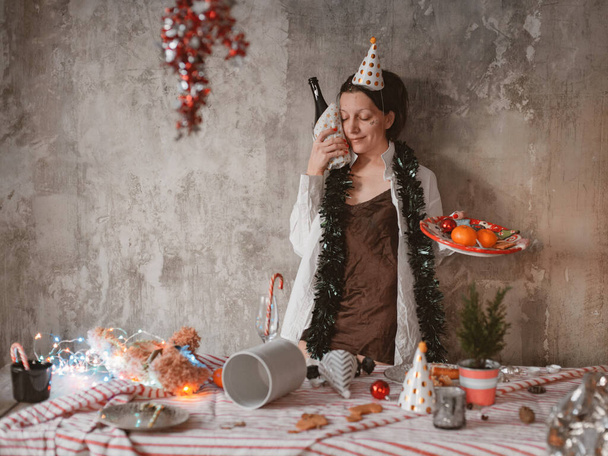 woman has a hangover after a holiday in the morning with a bottle of alcoholic champagne - Fotografie, Obrázek