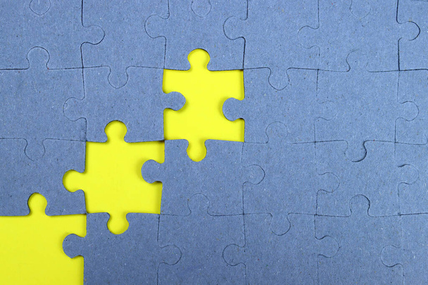 Onafgewerkte puzzel op een gele achtergrond, business concept, doel te bereiken - Foto, afbeelding