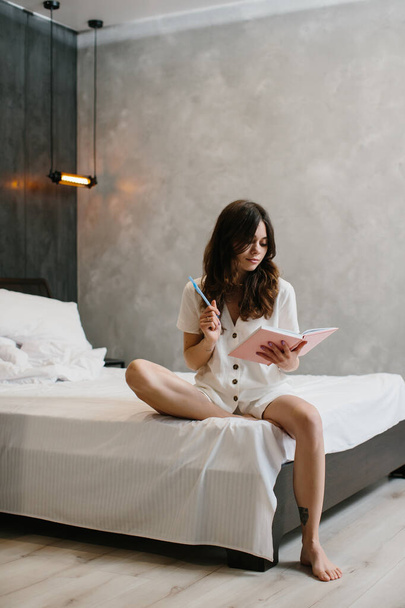 Beautiful Woman Writing Notes in Bed at Home - stock photo - Photo, Image