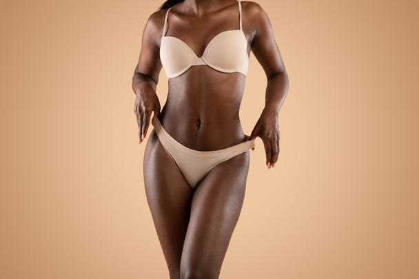 Αφροαμερικανή με εσώρουχα που δείχνει το τέλειο σώμα της. - Φωτογραφία, εικόνα