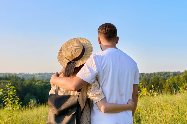 Rear view, happy middle aged couple looking at the horizon on summer nature - Фото, зображення