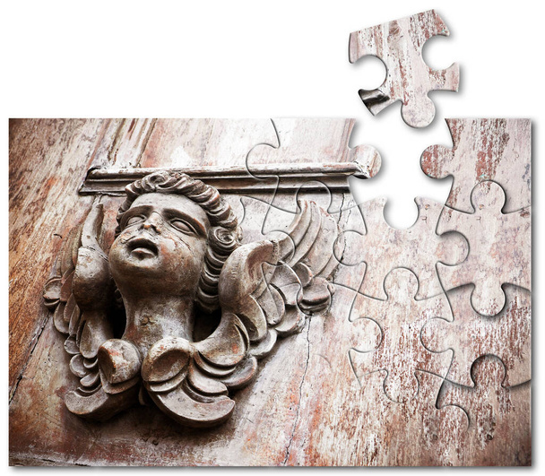The slow faith building or loss  - concept with a sculpture of an angel on a wooden door - faith building or loss concept in jigsaw puzzle shape - Zdjęcie, obraz