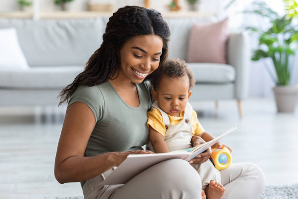 Caring African American Mommy Reading Book For Her Toddler Son At Home - Фото, изображение