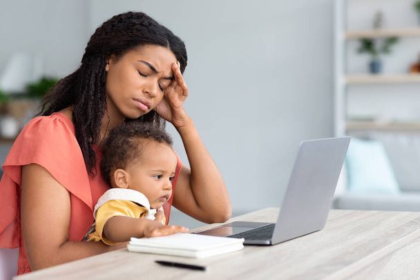 Young Black Woman With Infant Child Suffering Headache While Working On Laptop - Zdjęcie, obraz