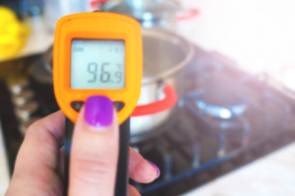 Foto borrosa. Termómetro infrarrojo de medición de cocina. Primer plano  - Foto, imagen