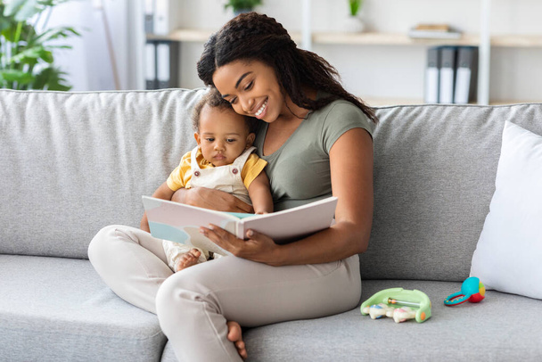Spending Time With Baby. Loving Black Mother Reading Book To Infant Child - Fotoğraf, Görsel