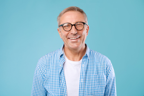 Portret uśmiechniętego dojrzałego mężczyzny w okularach pozujących w studio - Zdjęcie, obraz