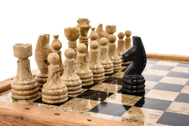 pièces d'échecs comme rivaux, au centre sur un échiquier en marbre corail beige et noir. Gros plan jeu concept compétition, Tournoi Classique. - Photo, image