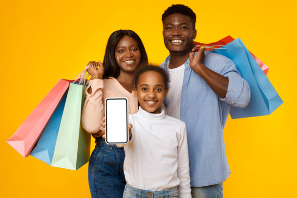 Nakupovat. Černá rodina zobrazující prázdnou obrazovku smartphonu pro mockup - Fotografie, Obrázek