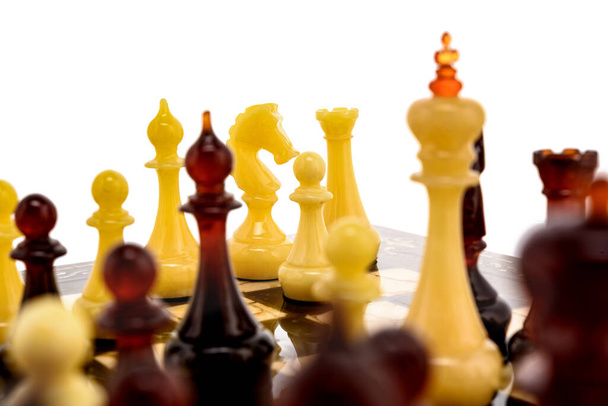 Přírodní jantarové různé šachové figurky stojící na perleťové desce v bílém. Závěrečná soutěž herních konceptů, Klasický turnaj konfrontace. - Fotografie, Obrázek