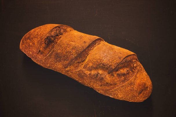 pan de masa fermentada fresco fondo negro - Foto, imagen