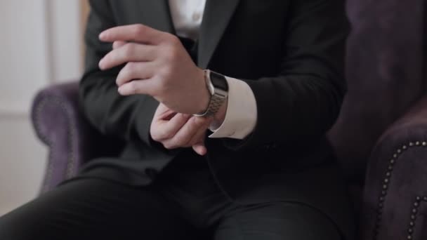 Uomo messo su orologio da polso, abiti da sposo, uomo d'affari in attesa di incontro, mano con orologio - Filmati, video