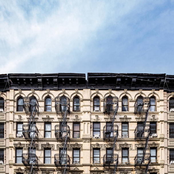 Old apartment buildings in the Lower East Side neighborhood of New York City with empty blue sky background above - Photo, Image