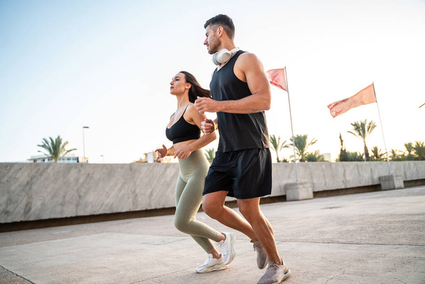 Healthy beautiful  couple running on the city street. Morning routine. Sport. Hobby. Personal training - Φωτογραφία, εικόνα
