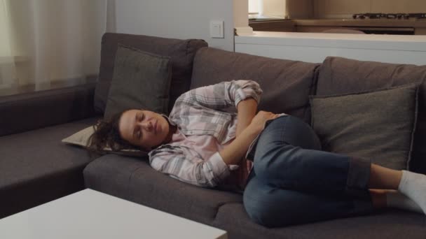 お腹を抱える大人の女性、屋内で腹痛に苦しむ - 映像、動画