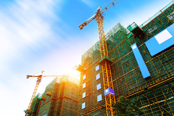 Crane and building construction site against blue sky - Photo, Image