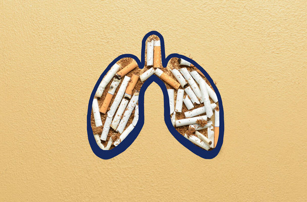 Pulmones hechos de cigarrillos y tabaco sobre fondo de color - Foto, Imagen