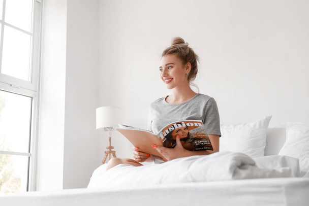 Aamulla kaunis nainen lukee lehteä sängyssä - Valokuva, kuva