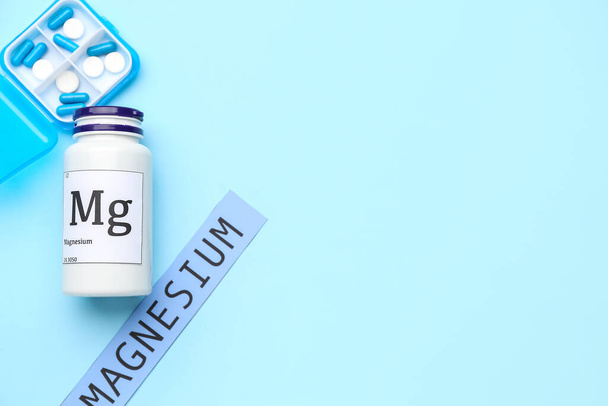 Plastic container with pills, bottle and word MAGNESIUM on color background - Photo, image