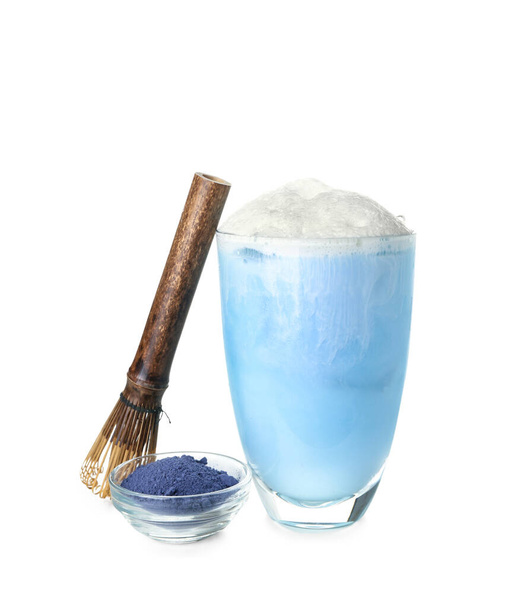 Glass of blue matcha latte, powder and chasen on white background - Фото, изображение