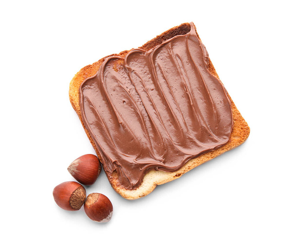 Bread with chocolate paste and hazelnuts on white background - Foto, Bild