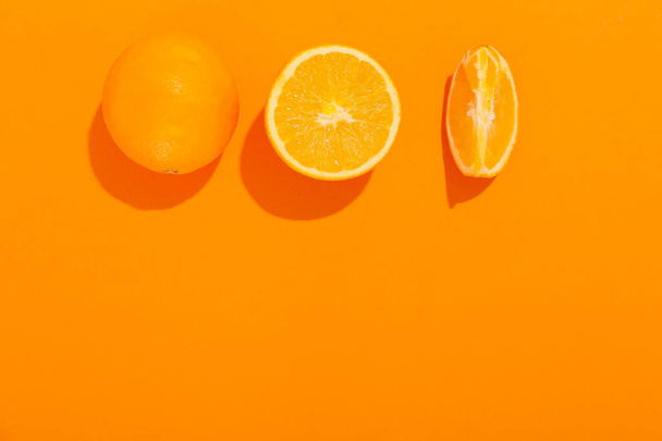 Φρέσκα κομμένα πορτοκάλια στο φόντο χρωμάτων - Φωτογραφία, εικόνα