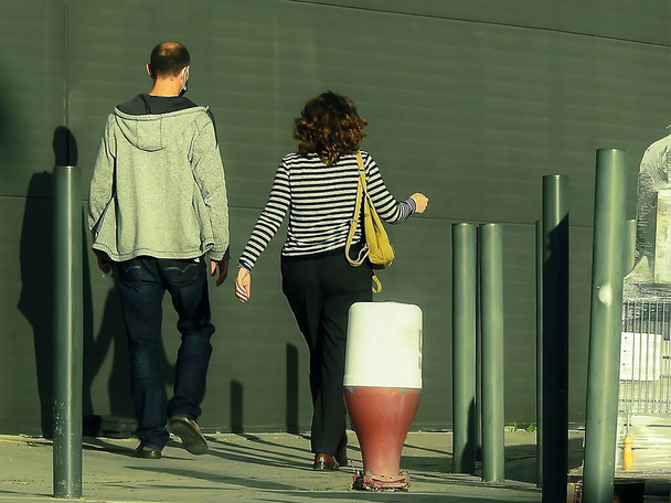 People walking on a sidewalk near a store - Foto, afbeelding