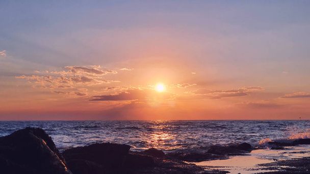 海の波の下で大きな太陽とカラフルな夕日. - 写真・画像