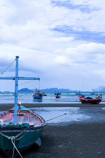 Traditional wooden fishing boats on a beach during monsoon season. South Thailand. Environment, climate change concepts. Selective focus. - Photo, Image