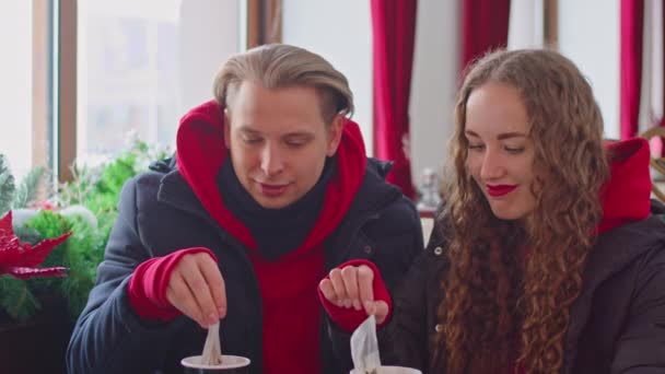 a guy and a girl drink tea in a cafe in winter - Filmagem, Vídeo