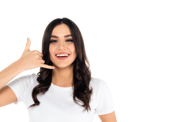 excited brunette woman showing call me gesture while looking at camera isolated on white - Photo, Image
