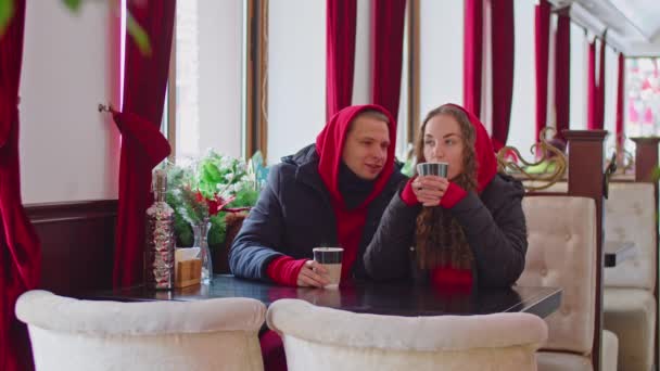 a guy and a girl drink tea in a cafe in winter - Filmagem, Vídeo