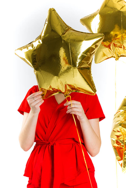 Joyful woman holding a golden stars on a white background. Celebrating birthday, anniversary. Shopping for holiday concept, saleout, black friday, cyber monday - Zdjęcie, obraz