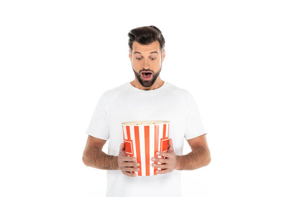 amazed man looking at big bucket of popcorn isolated on white - Fotoğraf, Görsel
