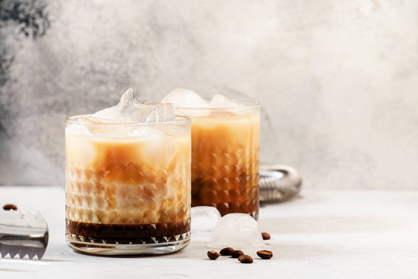 White russian cocktail, trendy alcoholic drink with vodka, coffee liqueur, cream and ice, gray background, bar tools, copy space - Photo, image