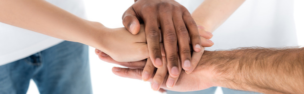 częściowy widok rozmazanych wielonarodowych przyjaciół łączących ręce na białym, banerowym banerze - Zdjęcie, obraz