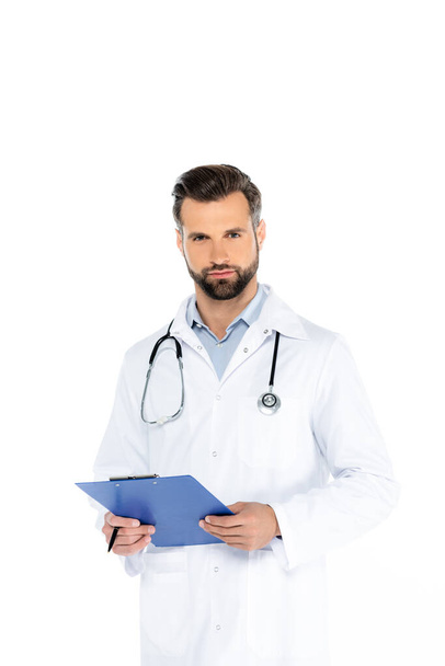 arts met stethoscoop en klembord kijken naar camera geïsoleerd op wit - Foto, afbeelding