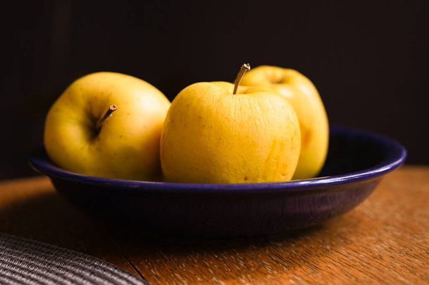 yellow apples on a wooden table - 写真・画像