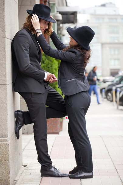 Young happy stylish couple in black hats posing on the street - Photo, Image