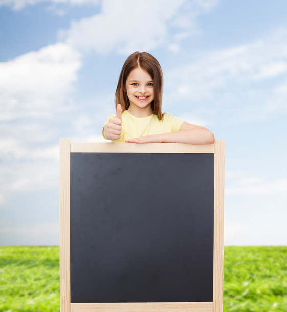 happy little girl with blank blackboard - Φωτογραφία, εικόνα